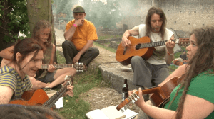 Festivalbesucher sitzen entspannt zusammen und machen Musik