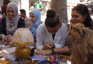 Junge Frauen bemalen Hände mit Henna-Ornamenten